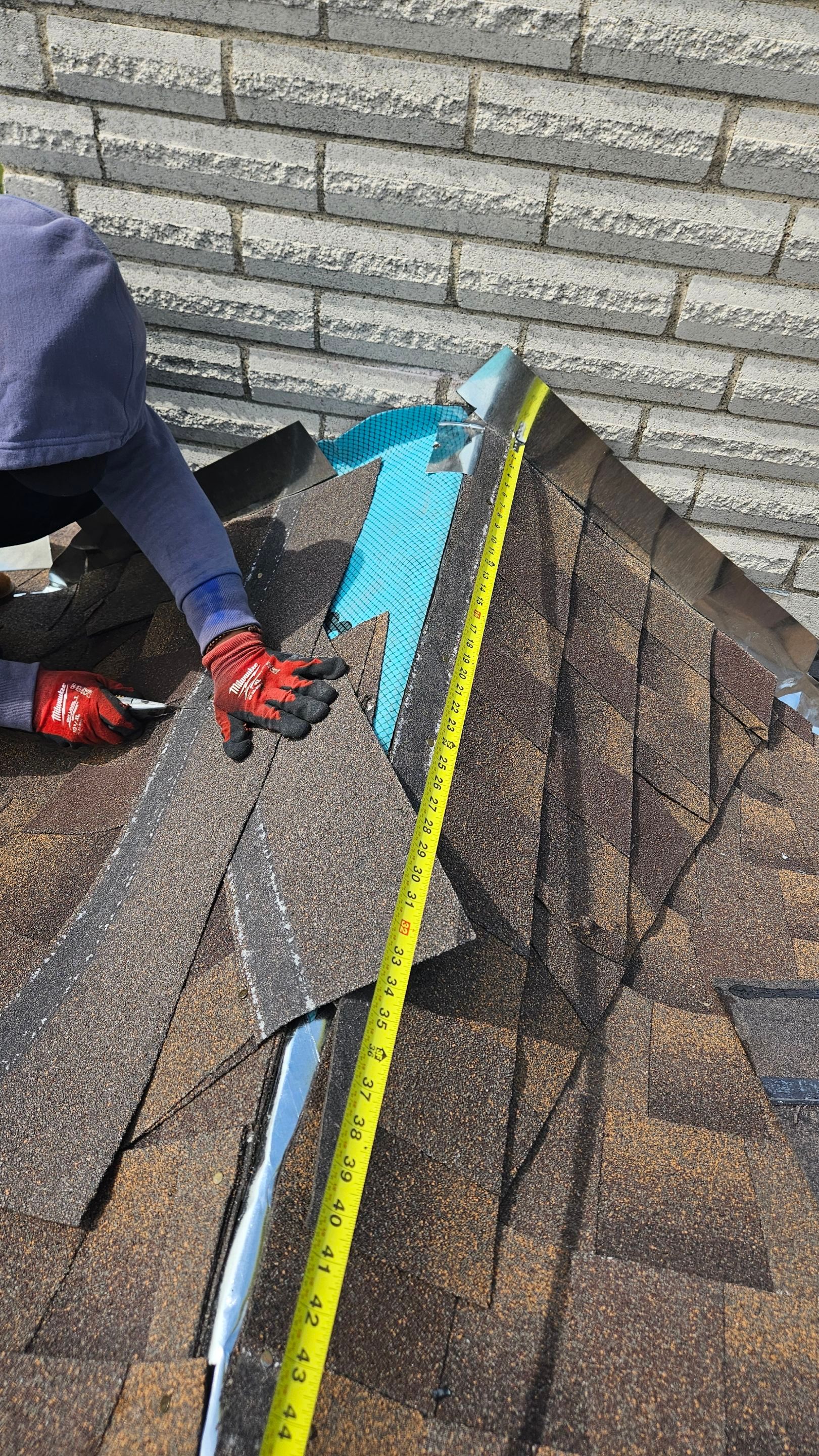 Crew repairing roof flashing beside a chimney, Gold Coast Roofing and Solar