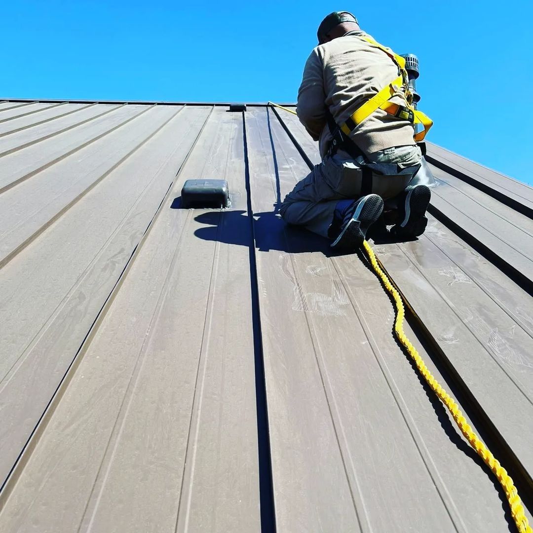 Roofer wearing a safety harness working on a metal roof from the Gold Coast job gallery