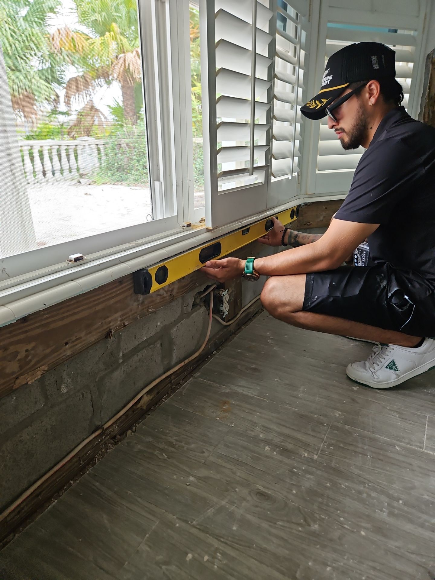 Crew member measuring below a window during restoration
