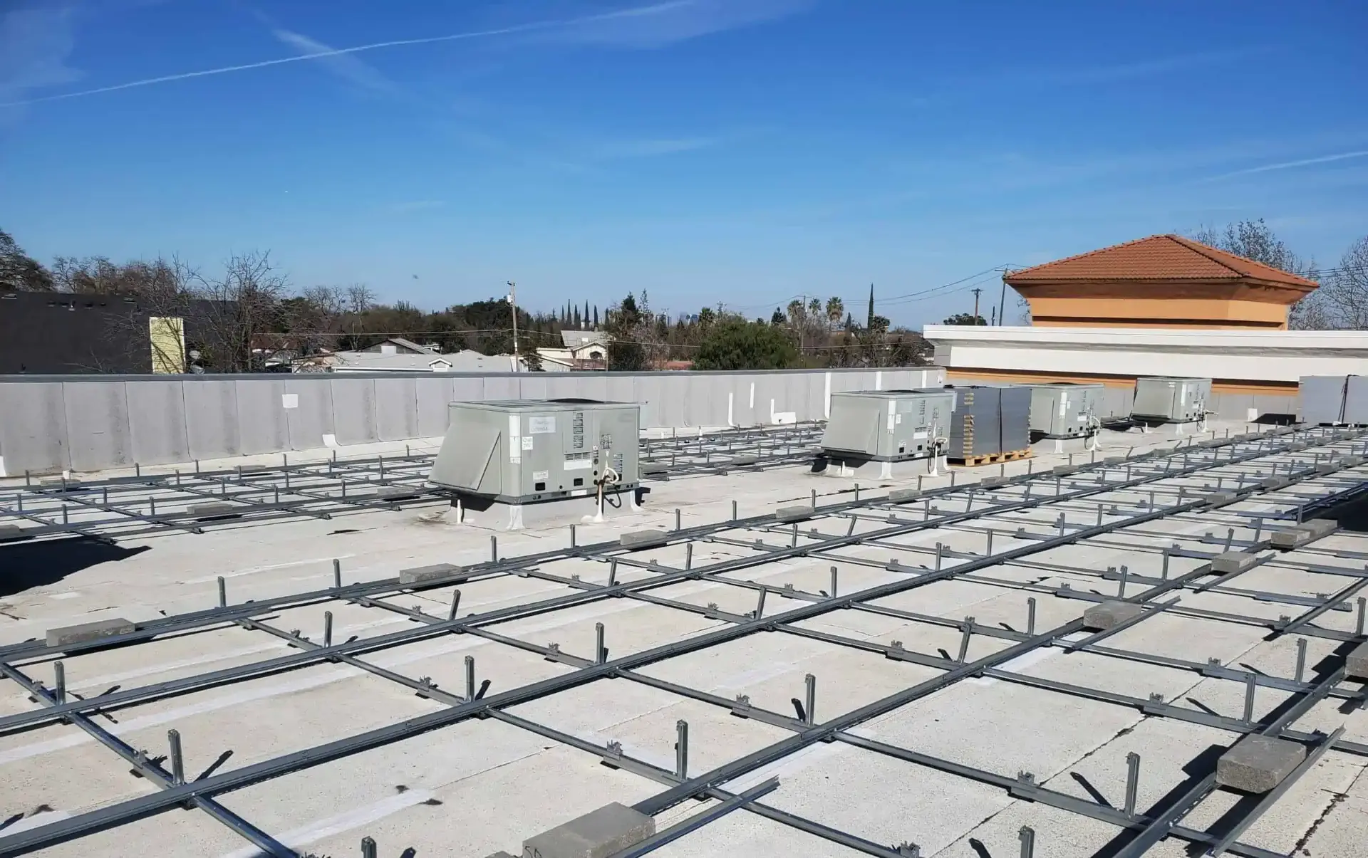 Solar racking installed around commercial rooftop equipment