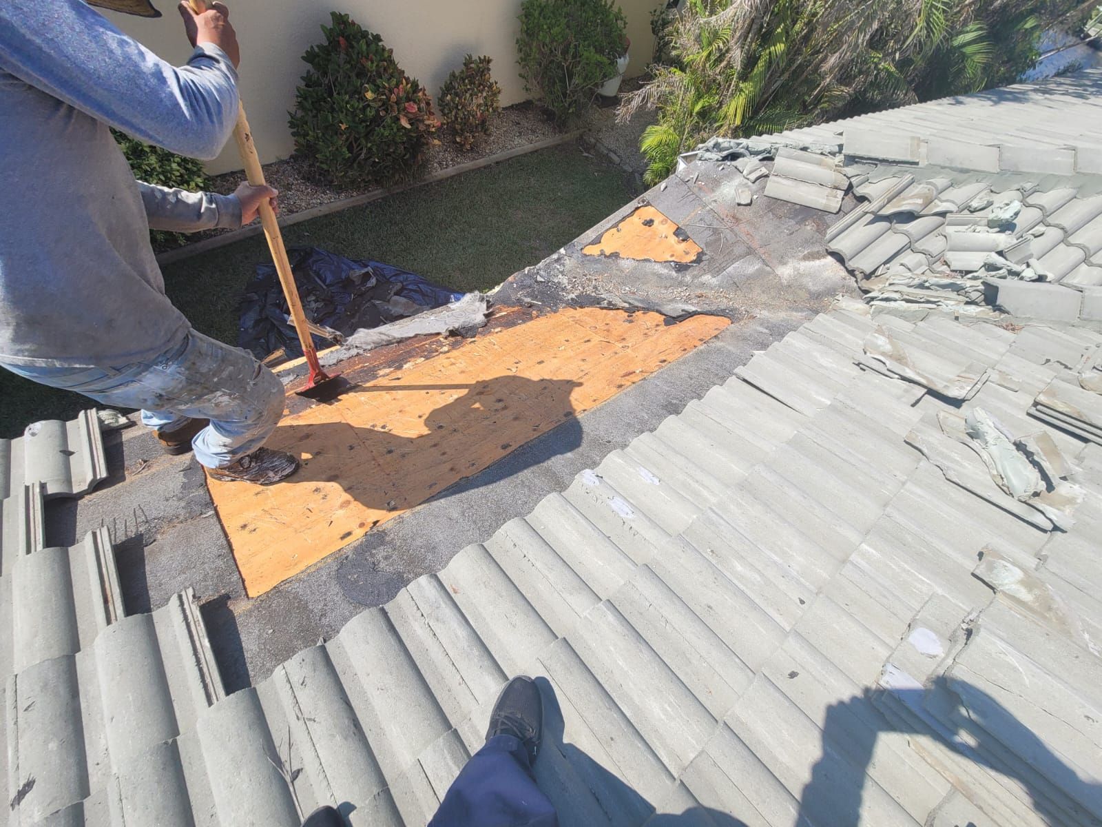 Crew repairing decking beneath removed roof tiles, Gold Coast Roofing and Solar