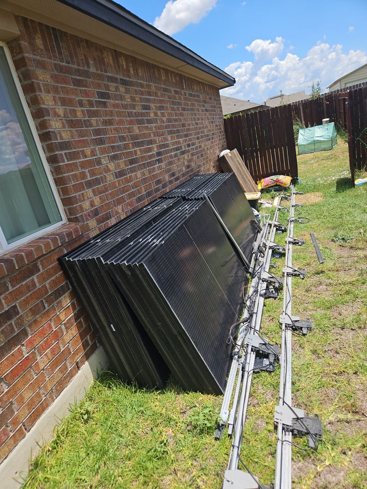 Solar panels and rails staged beside the home, military veteran solar project