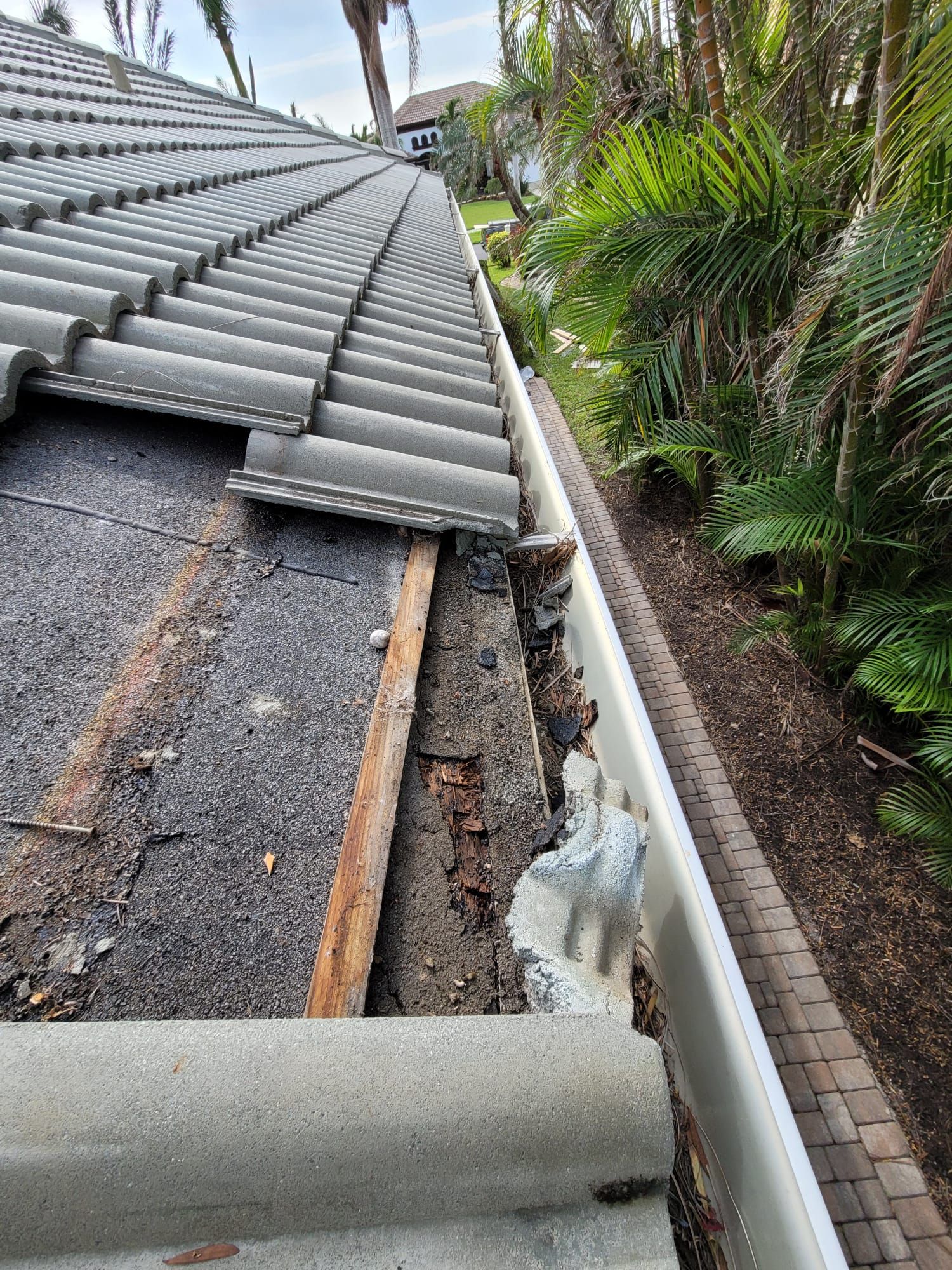 Damaged wood exposed beneath roof tiles, Gold Coast Roofing and Solar